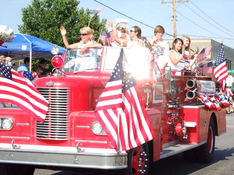 photo of fire truck and flag wavers